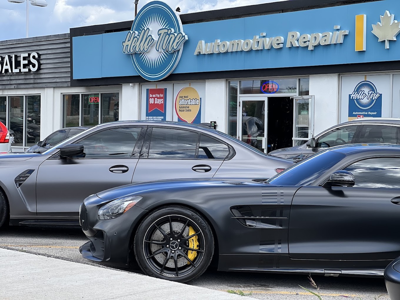 A matte grey Mercedes-AMG GT with yellow brake calipers and a grey BMW M3 parked outside Hello Tire