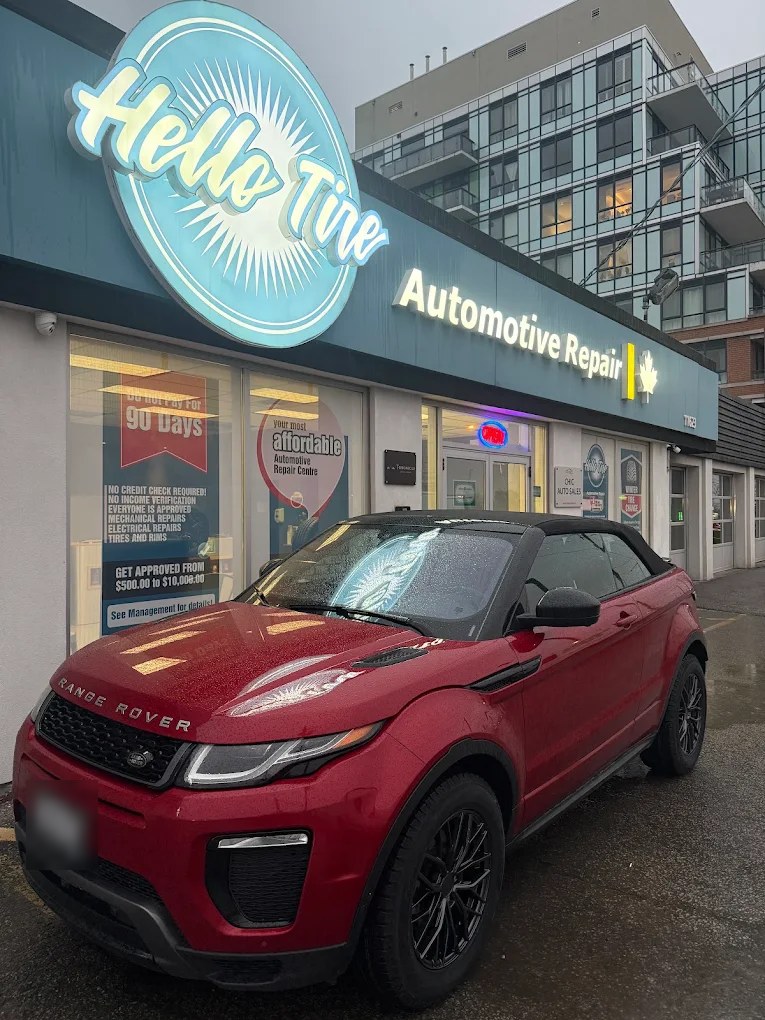 A red Range Rover parked in front of the Hello Tire sign
