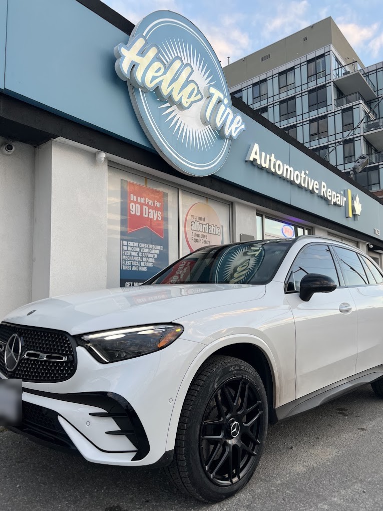 A white Mercedes-Benz GLC parked in front of the Hello Tire sign