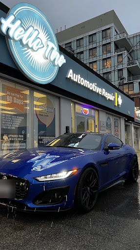 A blue Jaguar F-Type parked in front of the Hello Tire sign