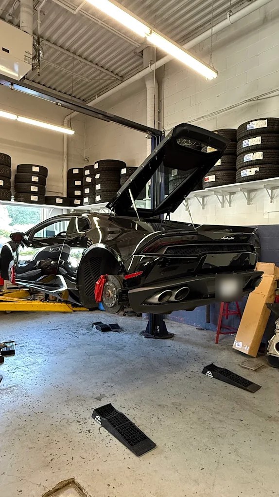 A black supercar on a Hello Tire lift with its wheels off