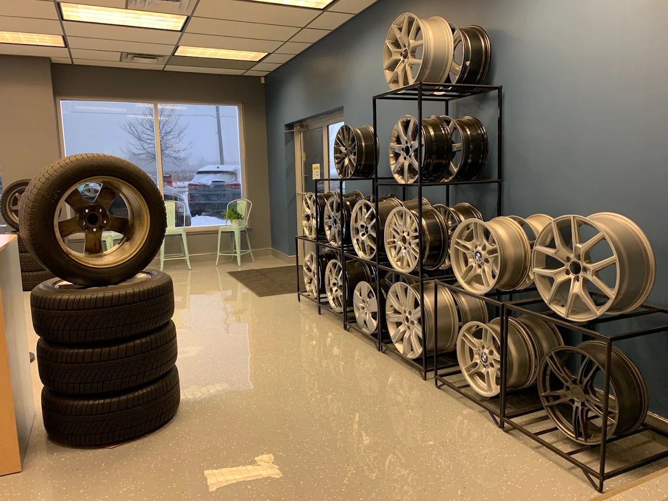Racks of alloy wheels and a stack of tires in the showroom