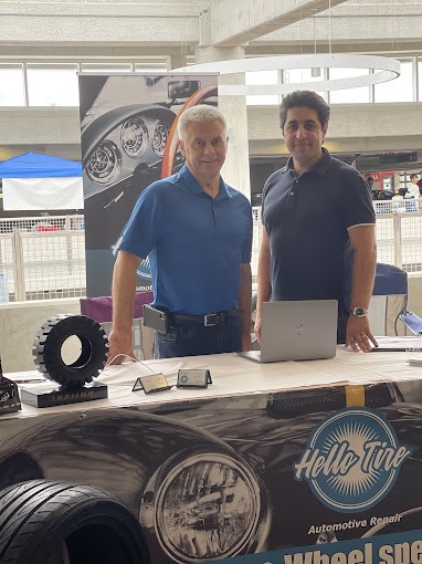 Boris, on the left, and Amir, on the right, standing behind a Hello Tire display table